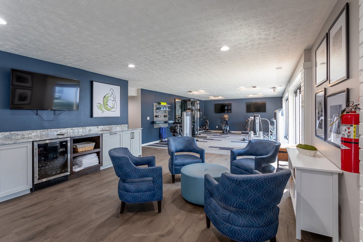 A modern fitness center with exercise equipment and a comfortable lounge area.