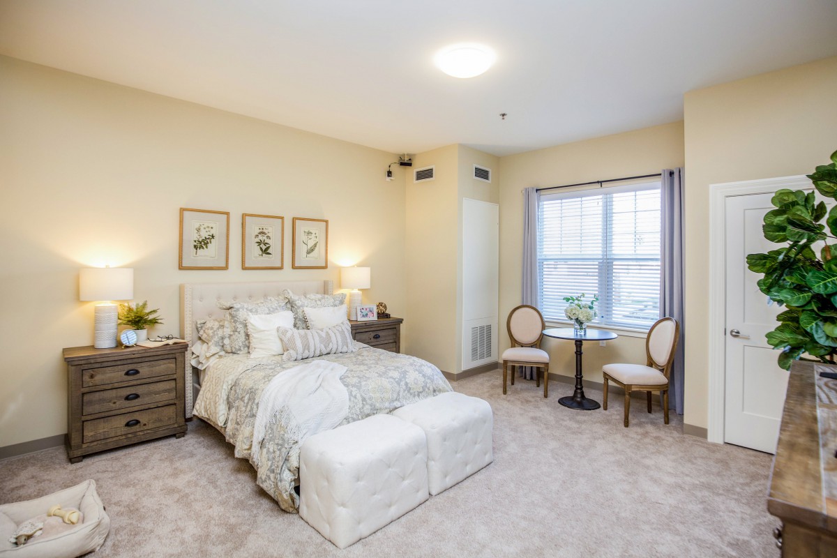 A cozy bedroom with a large bed, side tables, and decorative artwork on the walls.
