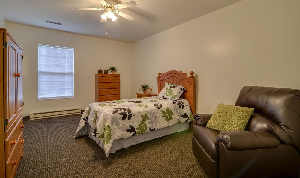 Cozy bedroom with a single bed, dresser, and armchair.