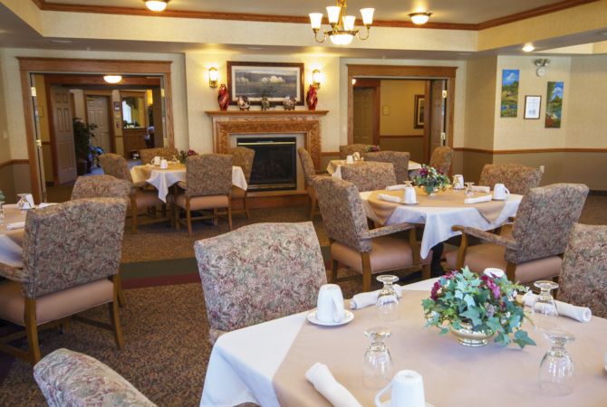 An elegant dining room with neatly set tables and comfortable chairs, ready for guests.