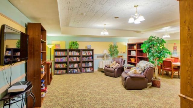 A cozy library reading area with bookshelves and comfortable armchairs.