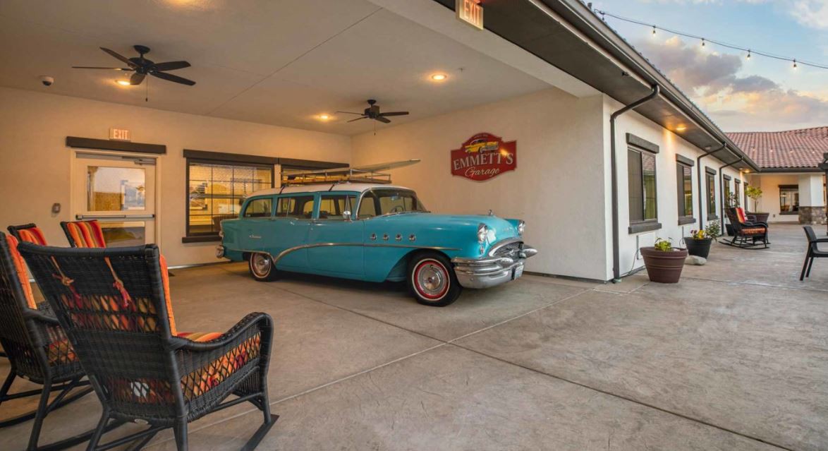 A classic turquoise station wagon parked in a retro-style garage.
