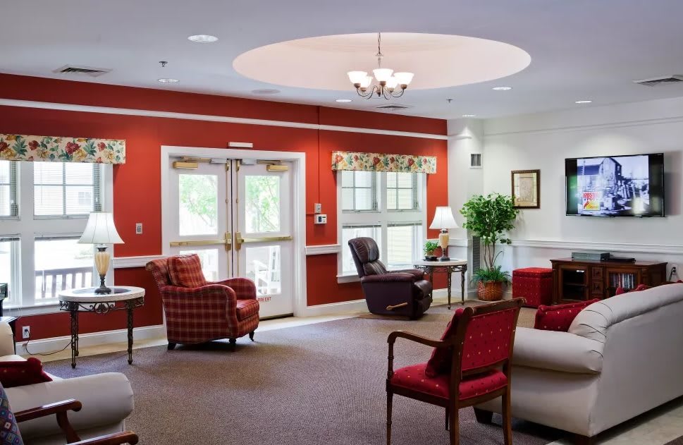 A cozy living room with red walls and comfortable seating.