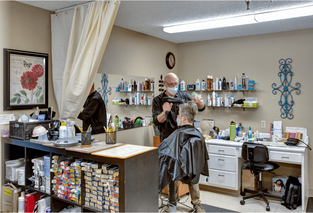 A barber giving a haircut to a customer in a salon.