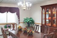 A classic dining room with a wooden table, elegant chairs, and a chandelier.