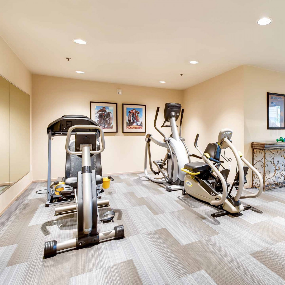 A modern home gym with exercise equipment including a treadmill and an elliptical machine.