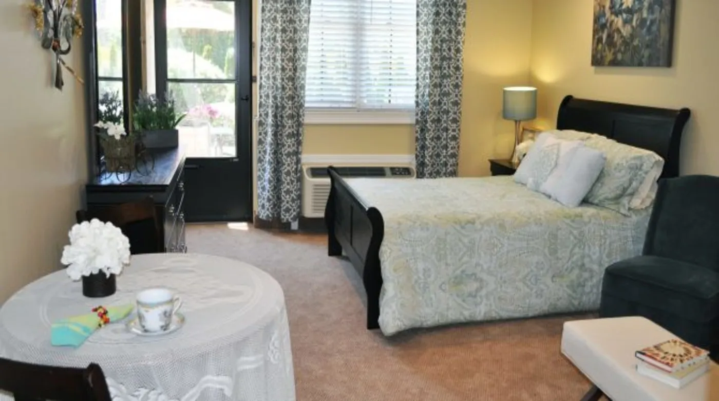 A cozy bedroom with a neatly made bed and elegant decor.