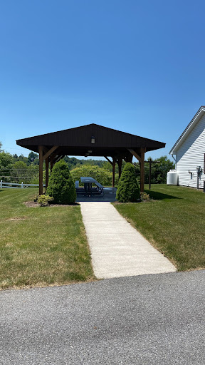 A sunny view of a pavilion with a well-kept lawn and pathway.