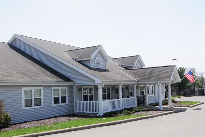 A row of modern residential houses with porches and gabled roofs.