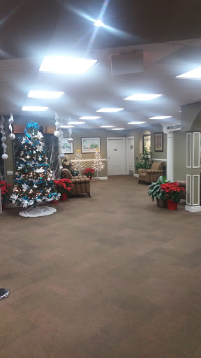 A festive lobby decorated for Christmas with a beautifully adorned tree and vibrant poinsettias.