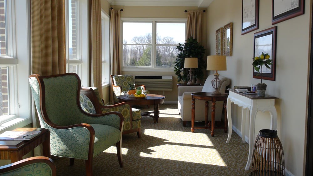 A cozy living room with elegant furniture and ample natural light streaming through the large window.