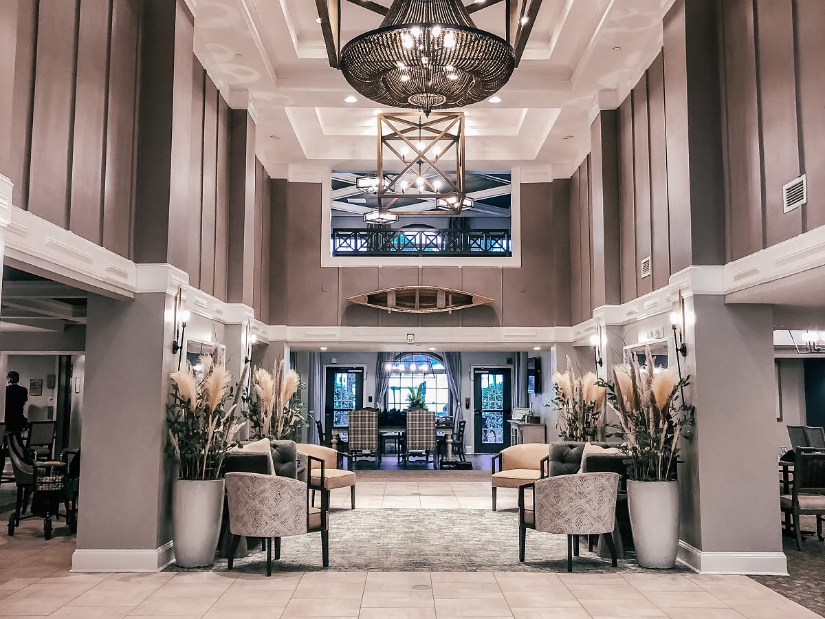 A luxurious hotel lobby with elegant seating and a grand chandelier.