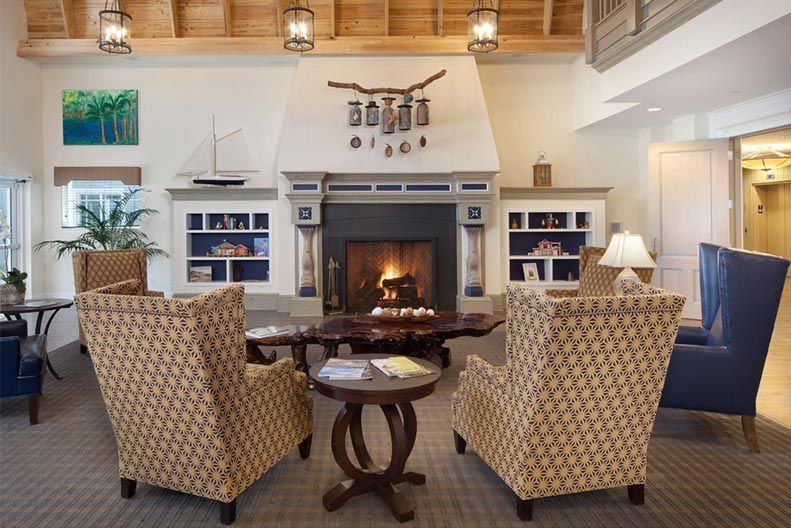 A cozy living room with a fireplace, armchairs, and bookshelves.
