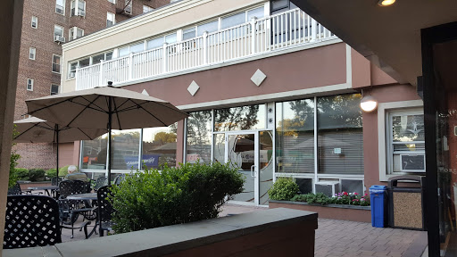 A cozy restaurant with outdoor seating surrounded by greenery.