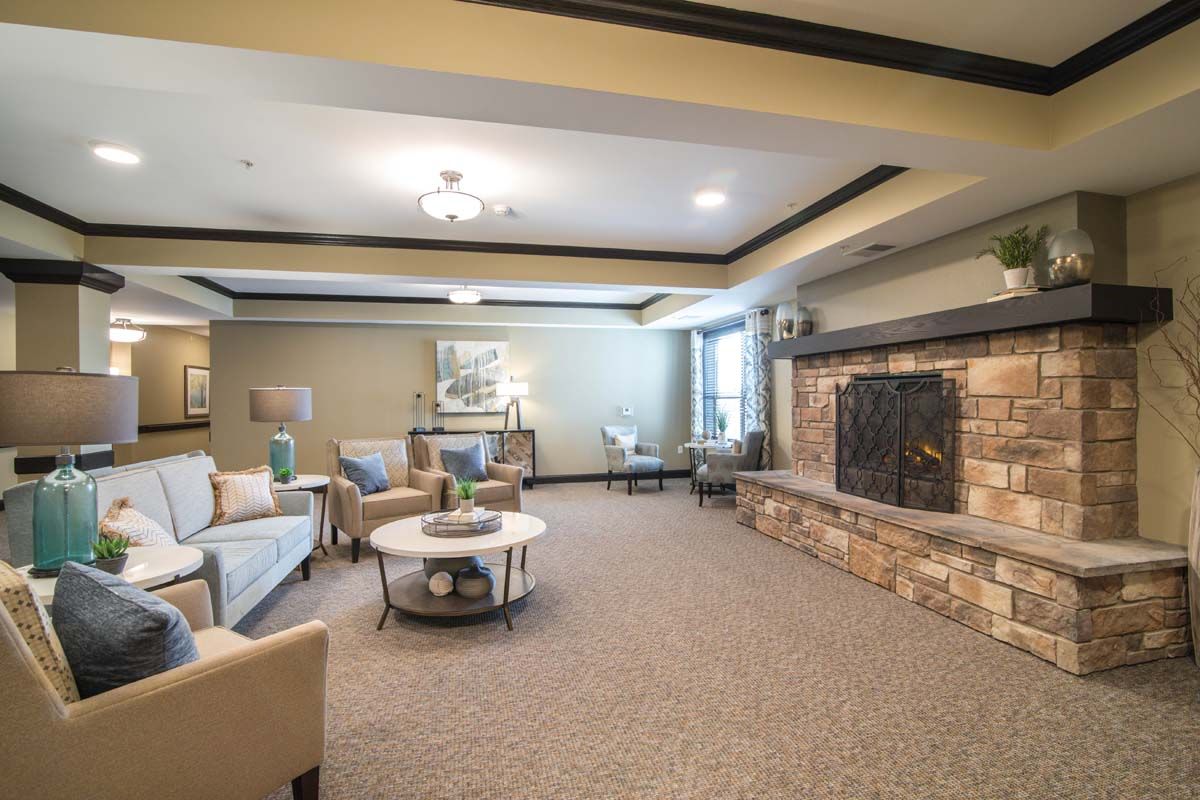 A cozy living room with comfortable seating and a stone fireplace.