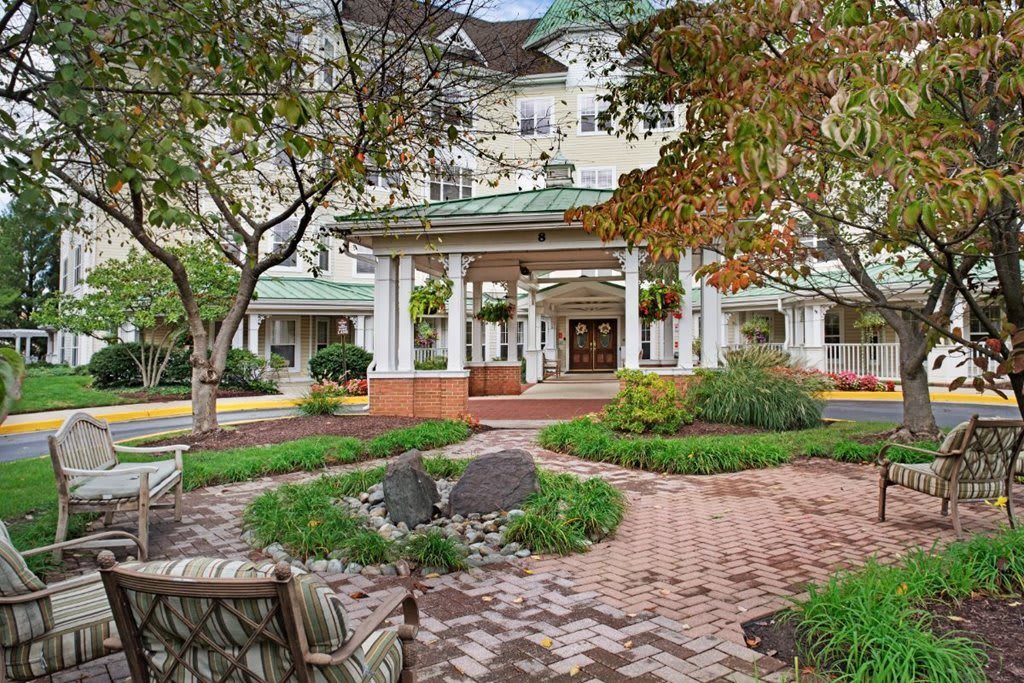 A scenic view of a building entrance surrounded by a well-maintained garden and trees.