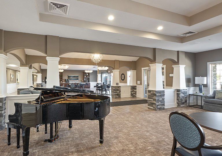 A spacious lounge area featuring a grand piano and stylish decor.