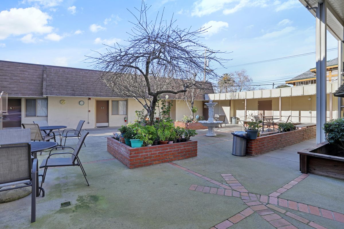 A peaceful courtyard with seating areas and planters on a clear day.
