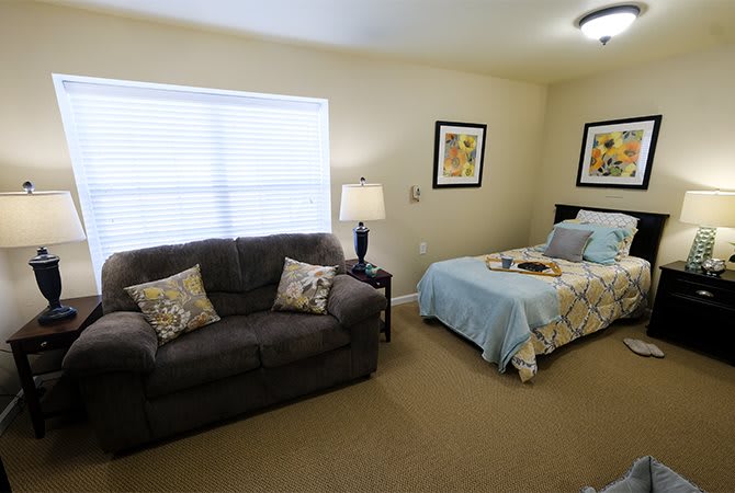 A cozy bedroom with a sofa, bed, and decorative elements.