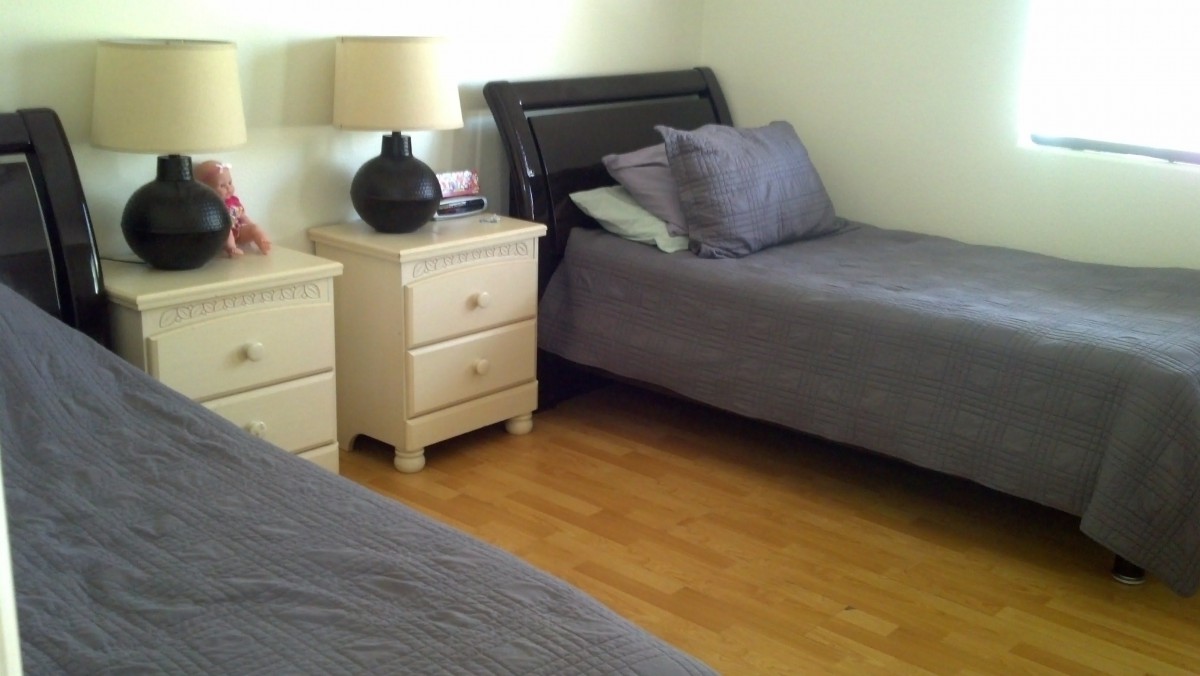 A tidy bedroom with twin beds and a shared nightstand.