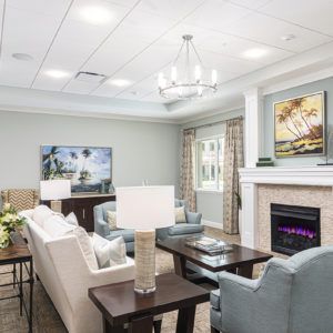 A beautifully designed living room featuring a comfortable sofa, elegant chandelier, and cozy fireplace.