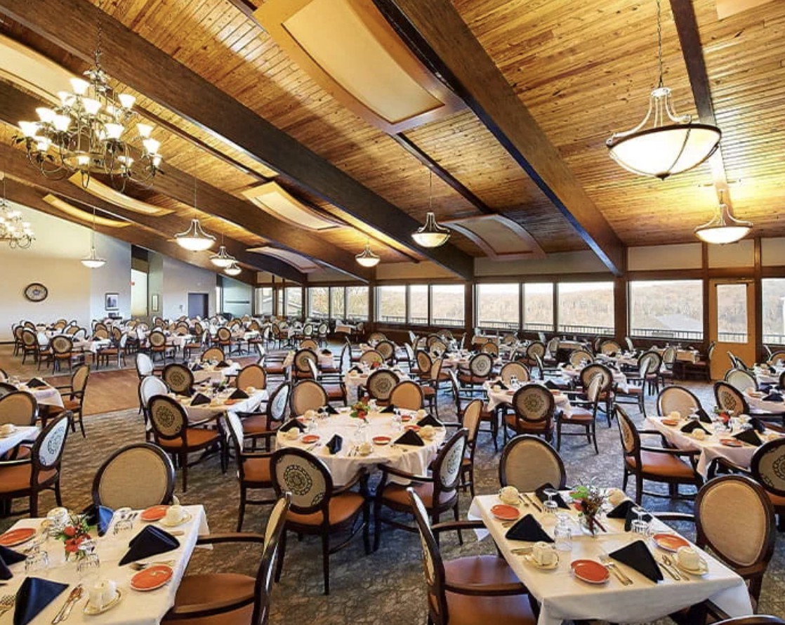 A spacious and elegantly designed dining hall with neatly arranged tables and chairs.