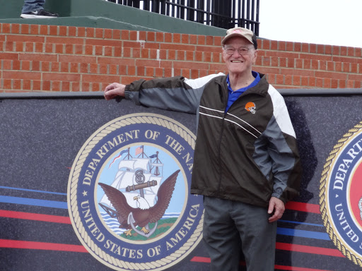 A person posing next to a military seal outdoors.