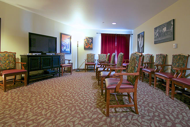 A conference room with neatly arranged chairs facing a large television screen.