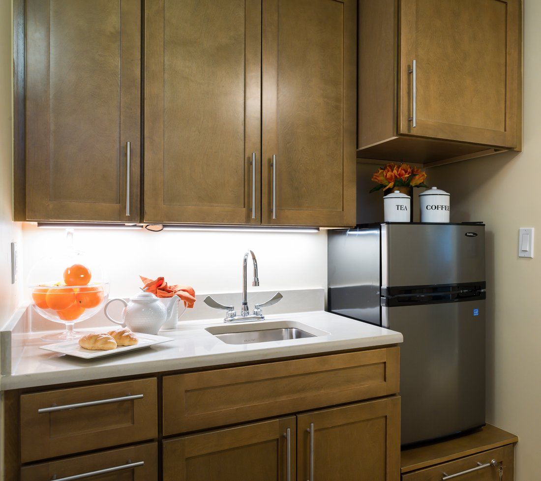 A modern kitchen with wooden cabinets, a stainless steel fridge, and decorative elements.