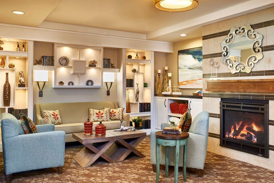 A modern living room with stylish furniture and decorative elements, featuring a cozy seating area and elegant shelving.
