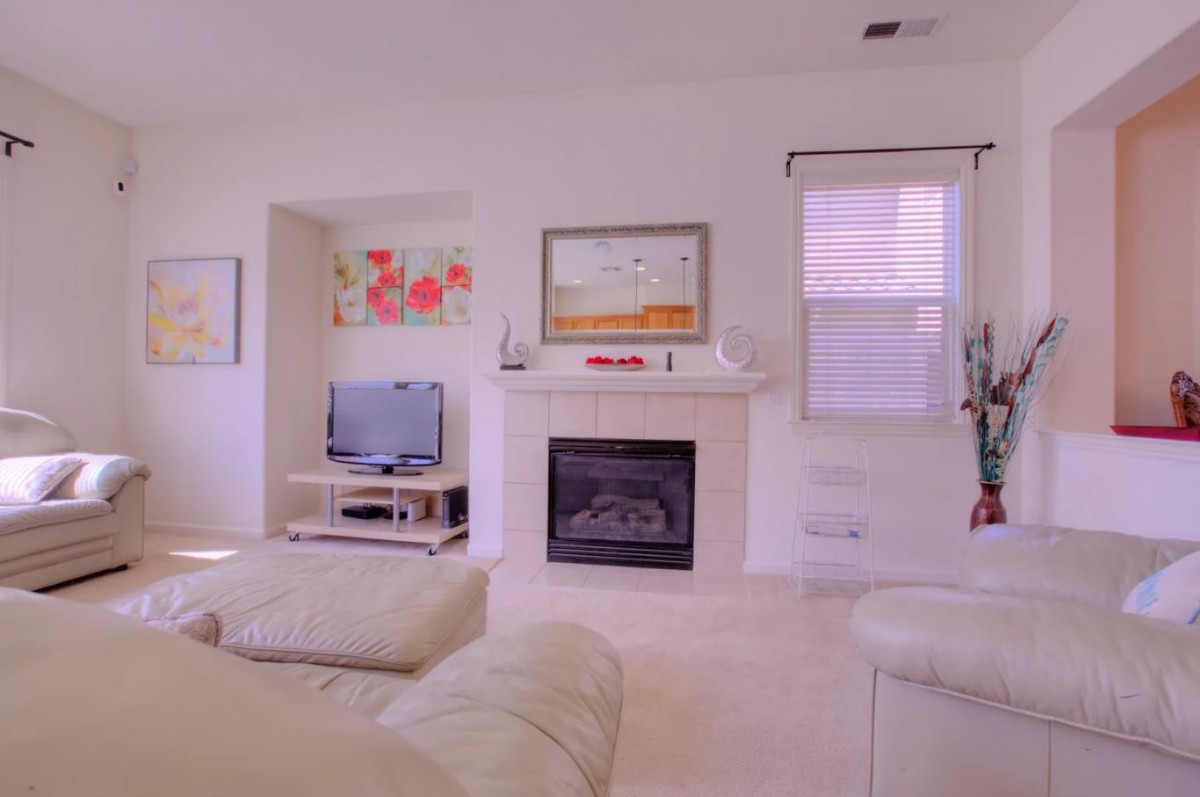 A cozy living room featuring a fireplace, television, and comfortable seating.