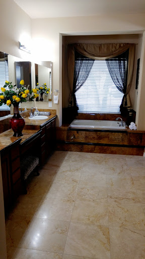 A beautifully designed bathroom featuring elegant fixtures, a cozy bathtub, and natural light filtering through the window.