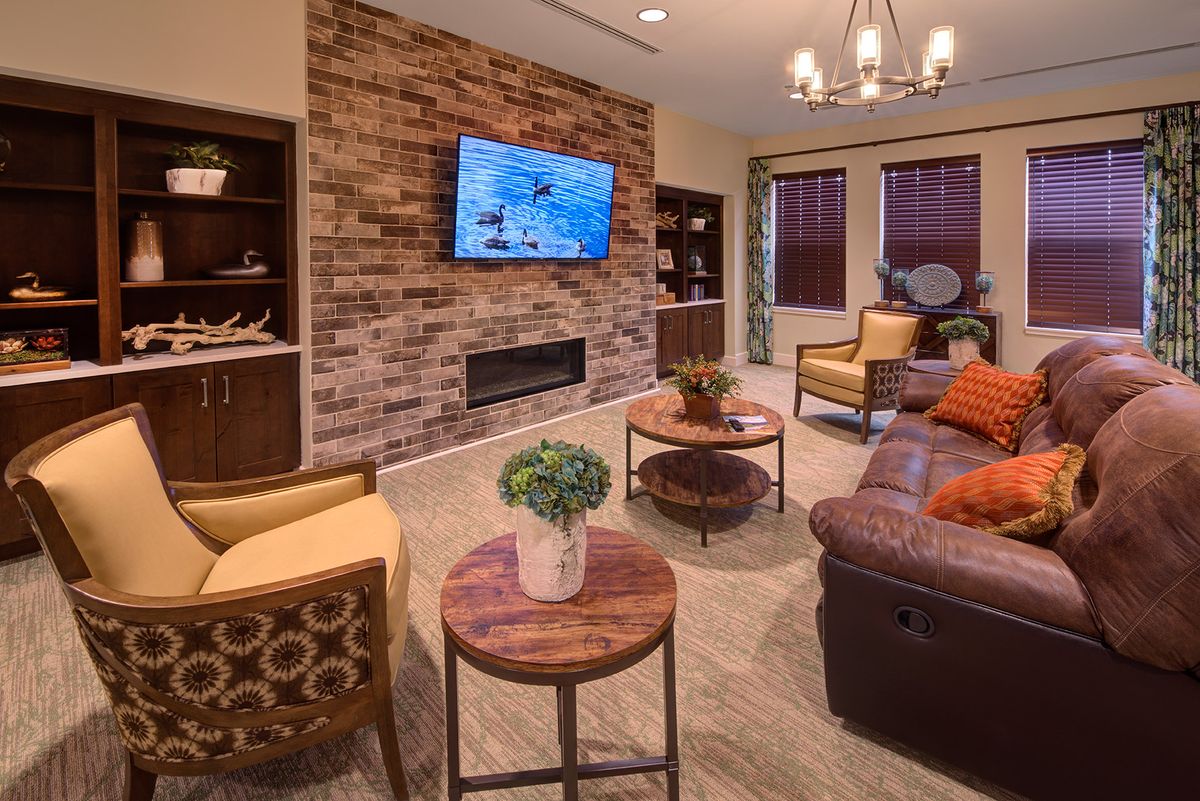 A cozy living room with stylish decor and a brick accent wall.