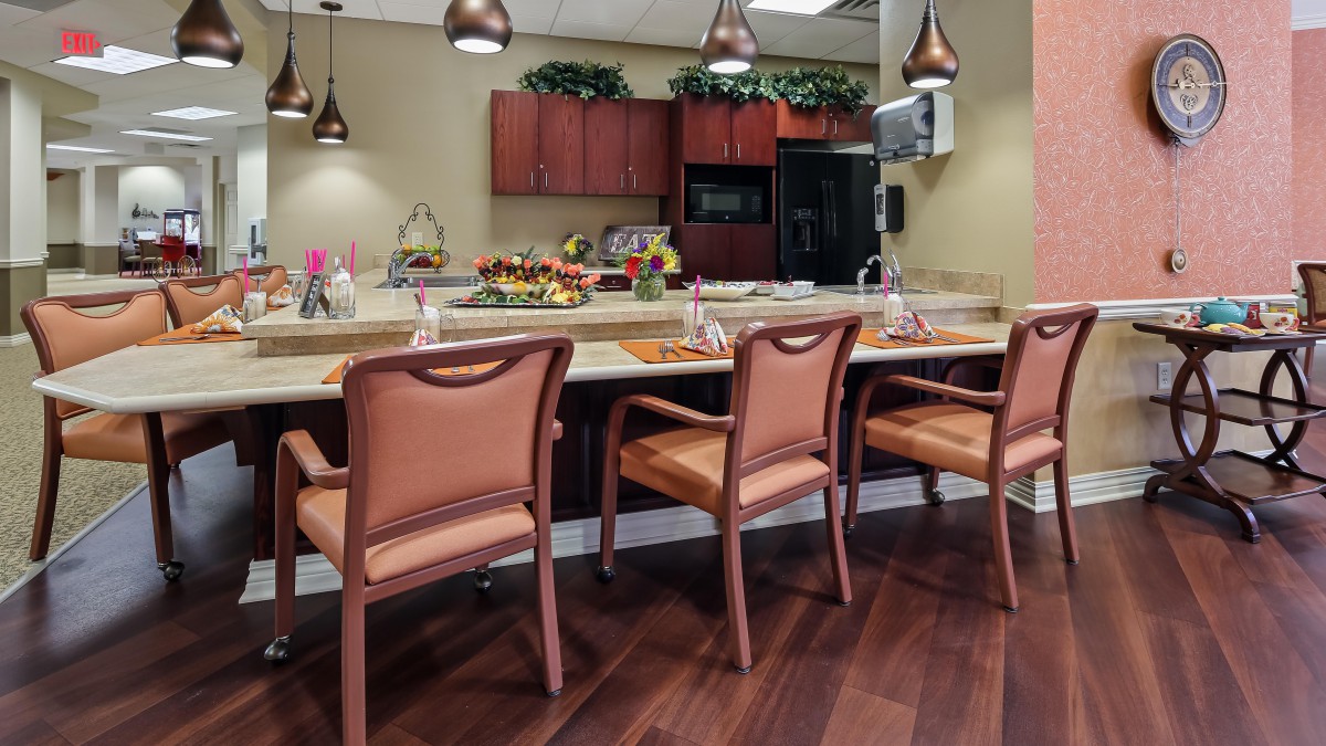 A cozy kitchen area featuring a counter with bar stools and decorative pendant lighting.