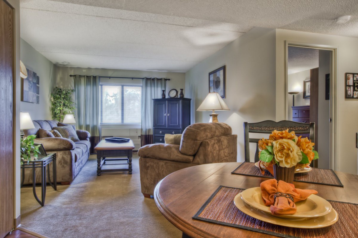 A cozy living room with comfortable sofas, a coffee table, and warm lighting.