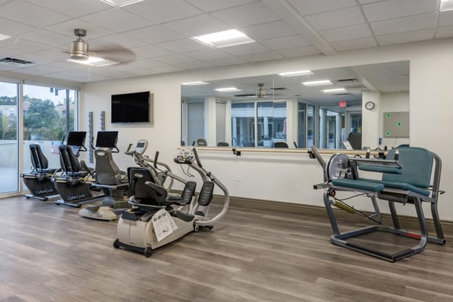 A modern gym equipped with treadmills and stationary bikes.