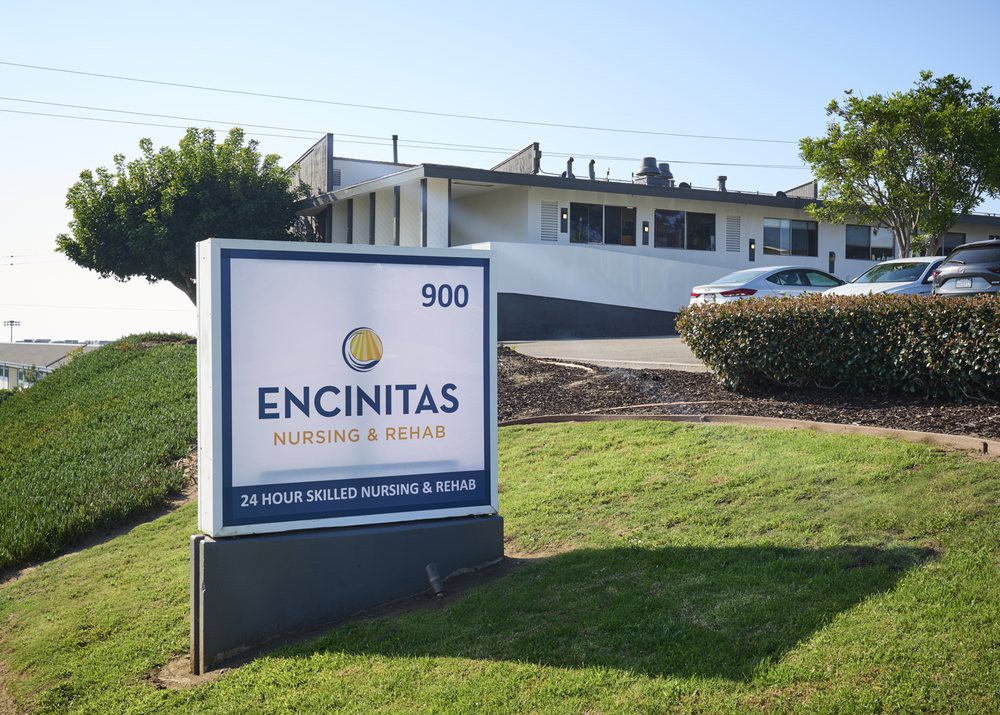 Sign for Encinitas Nursing and Rehabilitation Center with building in the background.