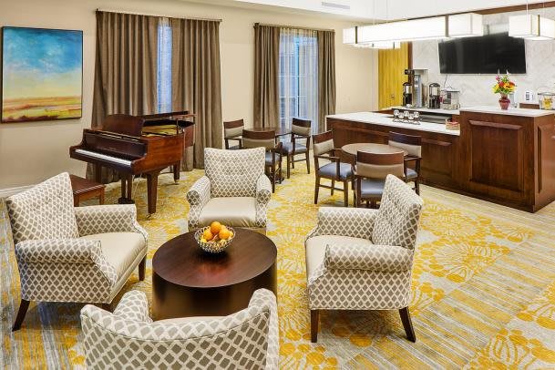 A cozy living room featuring a piano, comfortable seating area, and elegant decor.