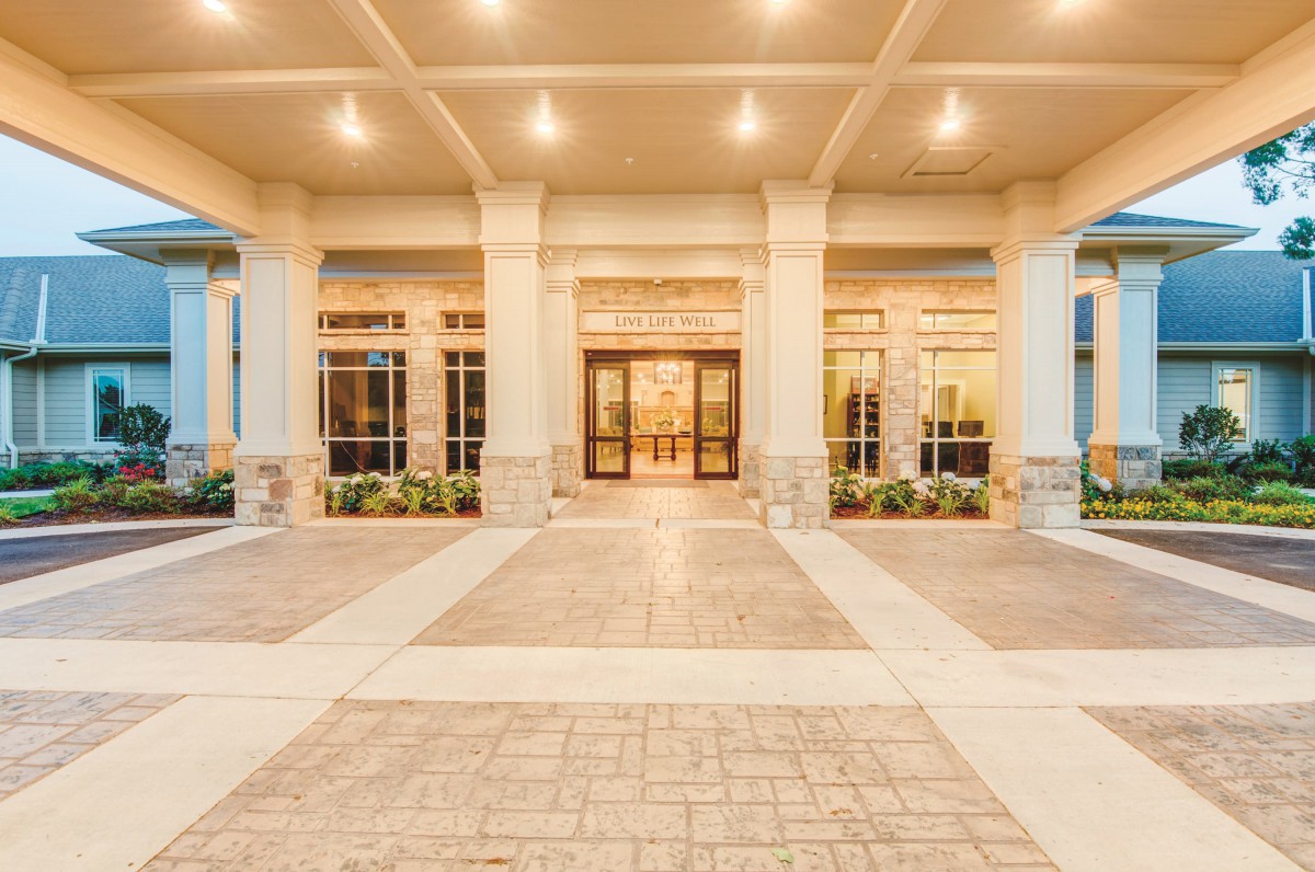 A well-lit building entrance with tall columns and large windows.