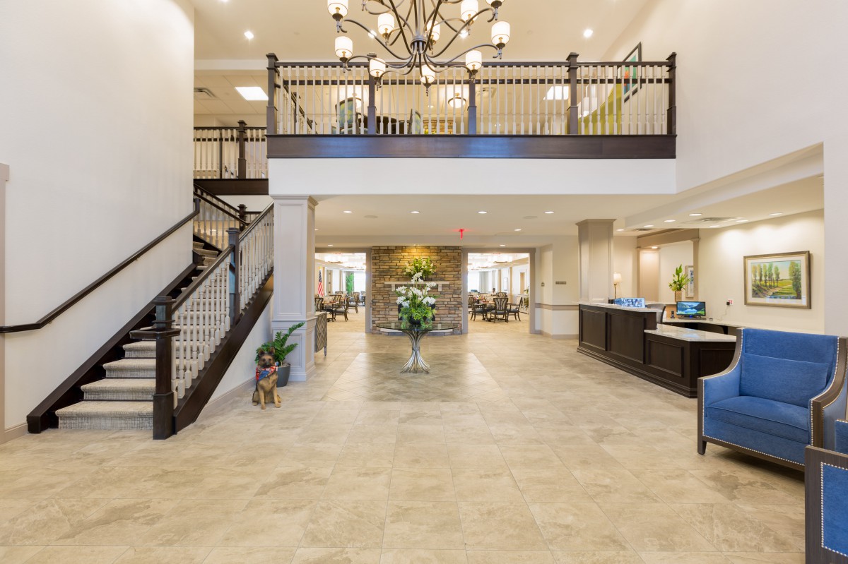 Spacious and elegant lobby with a chandelier and grand staircase.