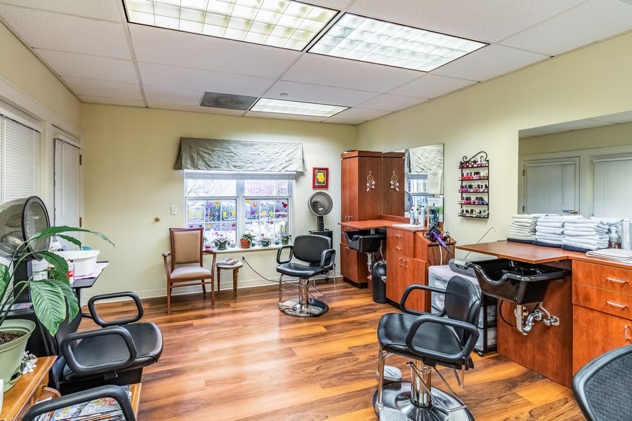 A well-lit hair salon interior featuring styling chairs and mirrors.