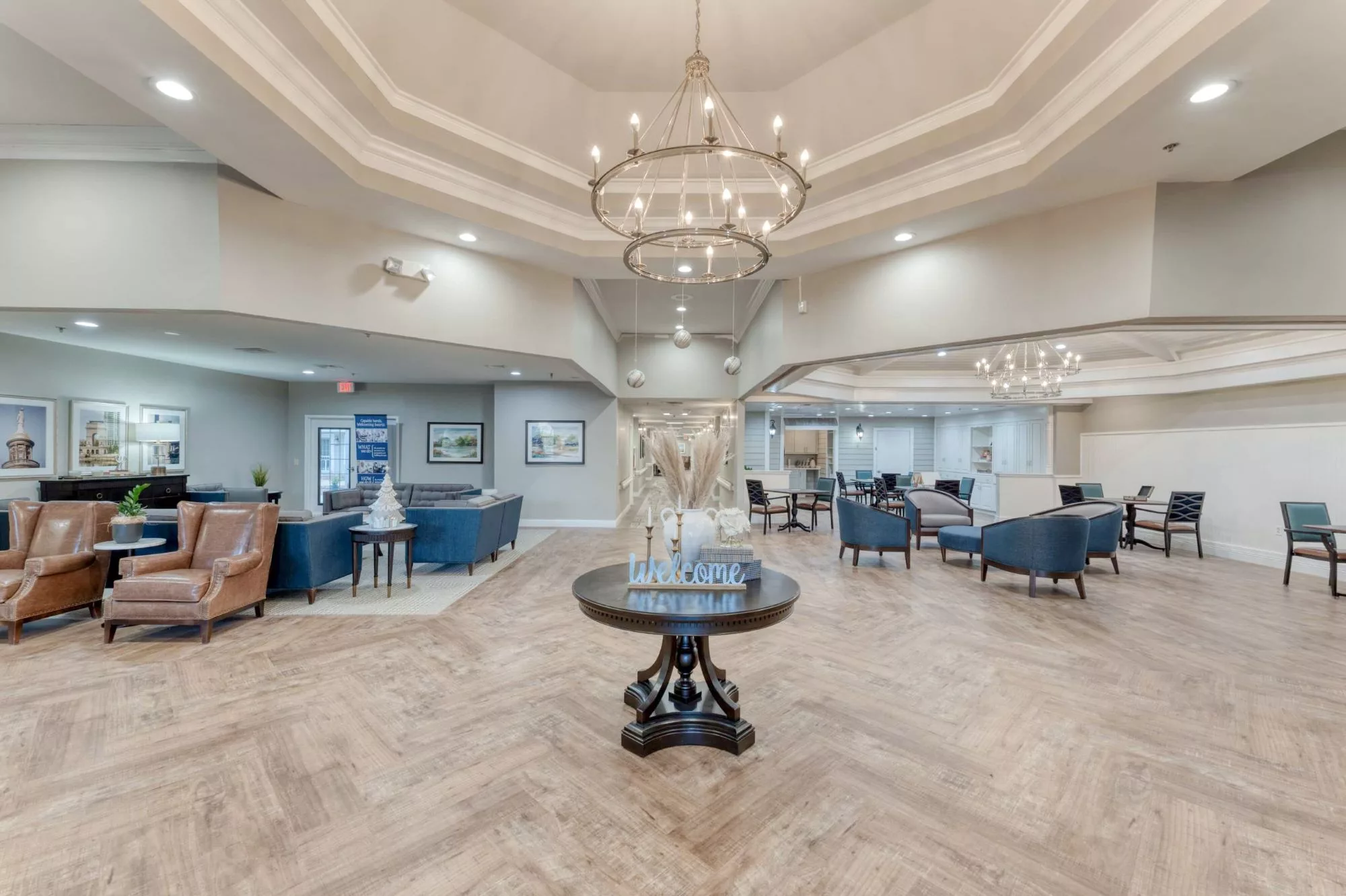 A spacious and elegantly designed lobby featuring chandeliers and a comfortable seating area.