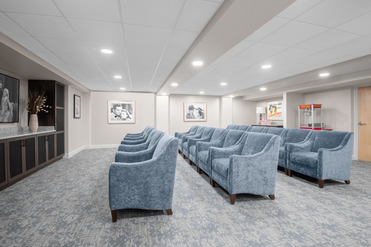 A modern waiting area with rows of blue chairs and soft lighting.