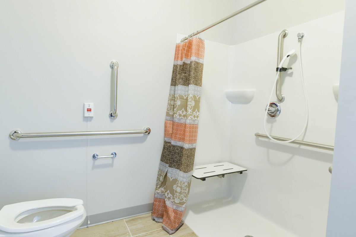 A handicap accessible bathroom with shower and grab bars.
