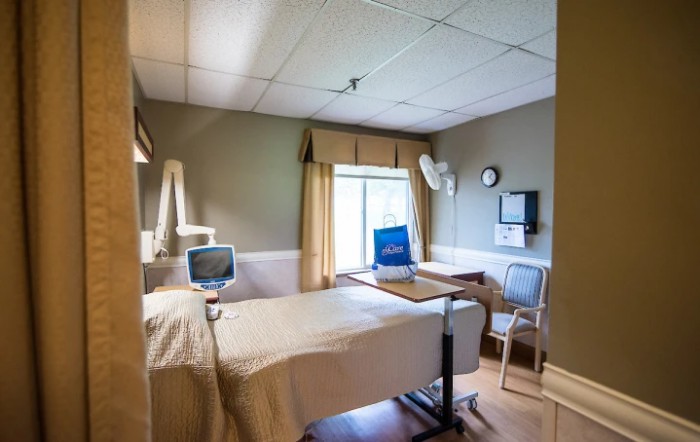 An empty hospital room with a bed and medical equipment.