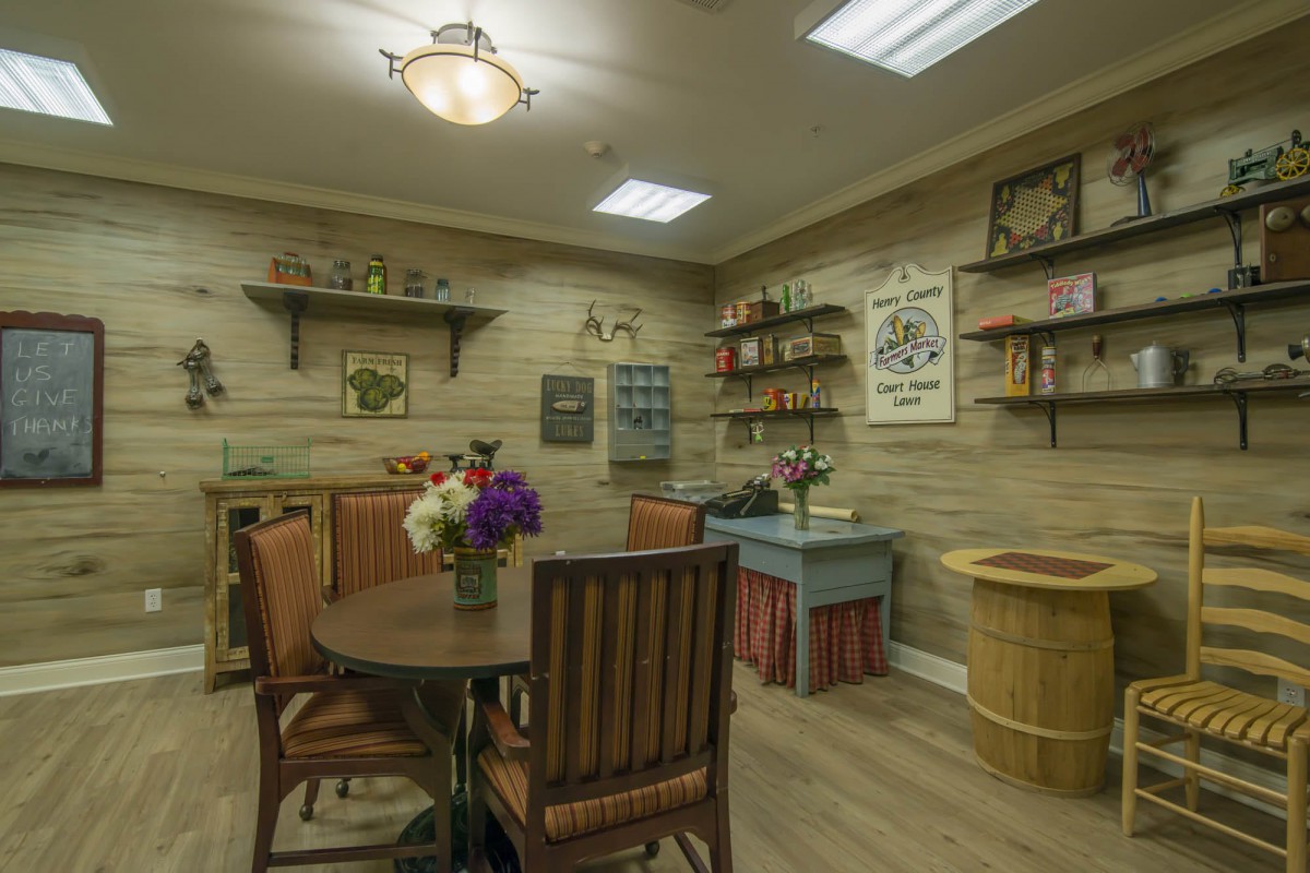 A cozy vintage-style room with a table, chairs, and decorative shelves.