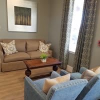 A cozy living room with a sofa, two chairs, and a coffee table.