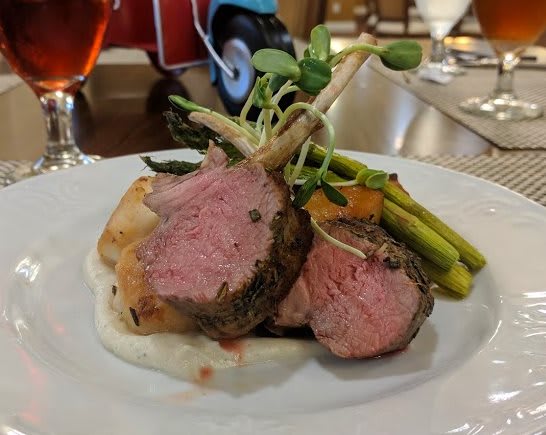 A gourmet plate of lamb with asparagus and vegetables.