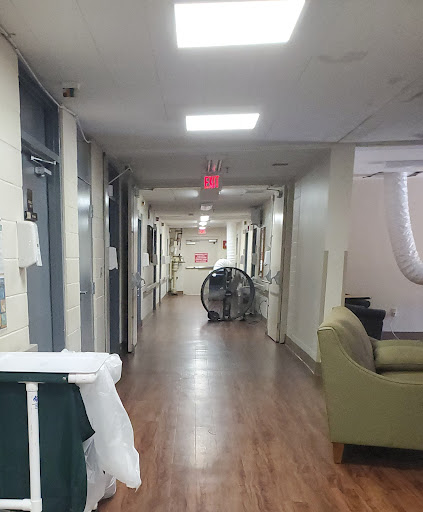 A serene corridor in a hospital with seating and medical equipment.