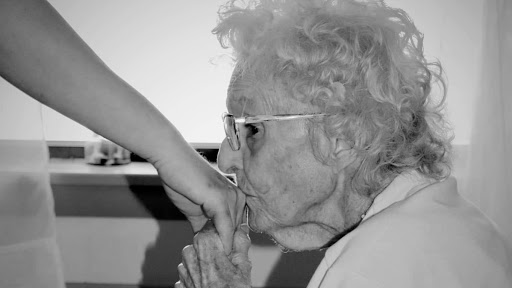 A tender moment captured between an elderly person and a younger individual, showcasing the beauty of connection across generations.